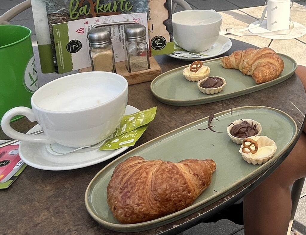 Tisch mit 2 Kaffeetassen und zwei Croissants