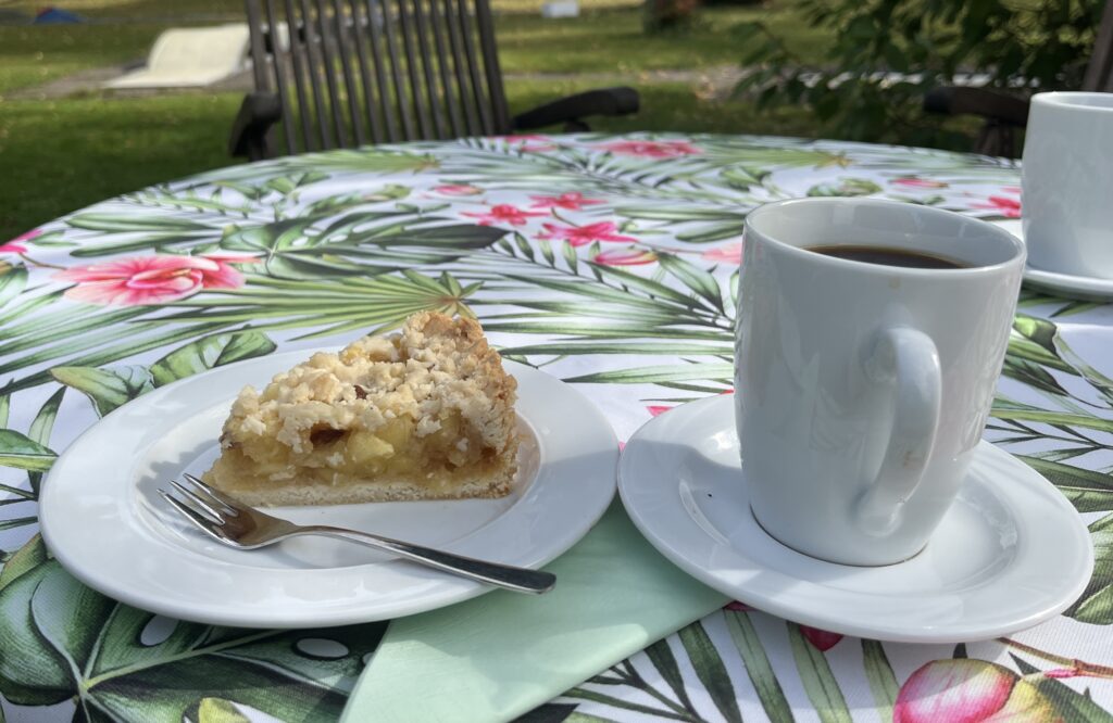 Eine Kaffeetasse und ein Teller mit einem Stück Kuchen
